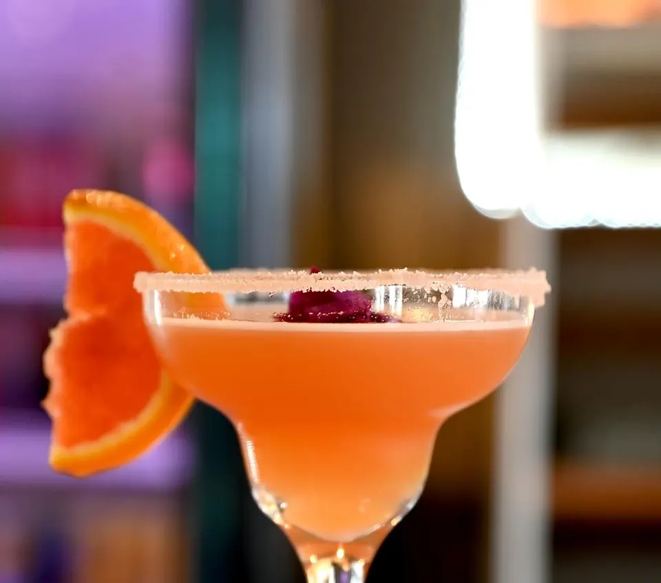 A citrus cocktail with a salted rim, served in a coupe