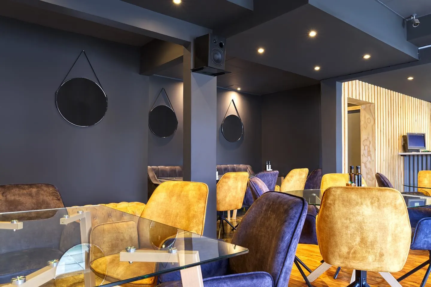 The Nocturne dining room after dark, set with velvet seating under warm downlights
